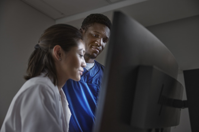 Doctor and technologist thinking about a case in front of Hermia workstation