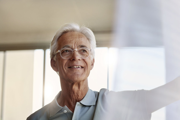 Older white male patient with white hair and glasses having a hopeful expression